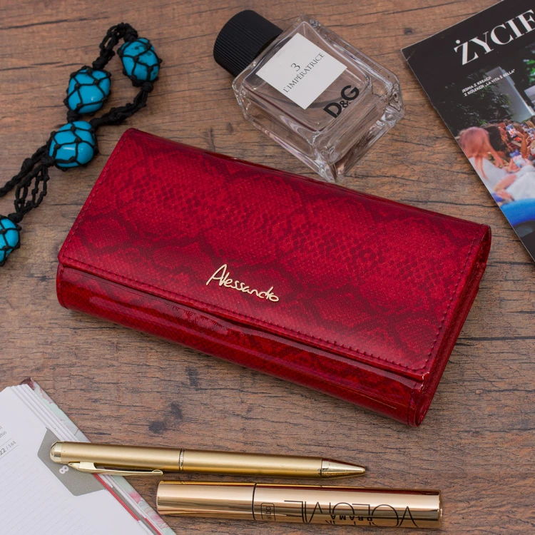 Zamknięty czerwony portfel Alessandro Paoli leżący na blacie wśród kosmetyków